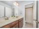 Well-lit bathroom features a double sink vanity and shower with neutral color palette at 1009 Travern Dr, Raleigh, NC 27603