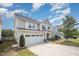 A view of the exterior of a two story single Gathering home with a two car garage, lawn, and mature landscaping at 1009 Travern Dr, Raleigh, NC 27603