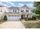 Charming two-story home featuring a well-manicured lawn, inviting front porch, and a convenient attached two-car garage at 1009 Travern Dr, Raleigh, NC 27603
