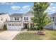 Charming two-story home featuring a well-manicured lawn, inviting front porch, and a convenient attached two-car garage at 1009 Travern Dr, Raleigh, NC 27603