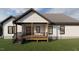 Inviting back porch offers a serene outdoor space with wood flooring and black railing at 101 Cochise Cv, Louisburg, NC 27549