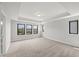 A bright, carpeted bedroom features multiple windows, tray ceiling, and neutral decor for a modern, spacious feel at 1011 Canary Pepper Dr, Durham, NC 27713