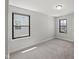 A light and bright carpeted bedroom with two windows and neutral paint at 1011 Canary Pepper Dr, Durham, NC 27713