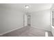 A neutral carpeted bedroom with a window and an open door to another room at 1011 Canary Pepper Dr, Durham, NC 27713