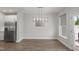 Open-concept dining area with modern chandelier, stainless steel appliances, and wood flooring at 1011 Canary Pepper Dr, Durham, NC 27713
