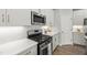 Stylish kitchen featuring stainless steel appliances, white countertops, herringbone backsplash, and white cabinets at 1011 Canary Pepper Dr, Durham, NC 27713