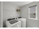 Bright laundry room featuring a washer, dryer, and storage shelving for efficient organization at 1011 Canary Pepper Dr, Durham, NC 27713