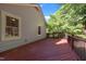 A view of the home's spacious wooden back porch with black railing surrounded by lush trees at 1040 Mills St, Raleigh, NC 27608
