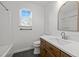 Bright bathroom features a white countertop, wood vanity, a large mirror, and a window for natural light at 1040 Mills St, Raleigh, NC 27608