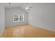 A bedroom with hardwood floors, ceiling fan, and a window at 1040 Mills St, Raleigh, NC 27608