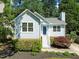 Charming light blue home features mature landscaping, white trim, and a brick foundation at 1040 Mills St, Raleigh, NC 27608