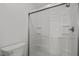 All-white shower stall with sliding glass doors and built-in shelving for storage at 1040 Mills St, Raleigh, NC 27608