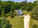 An aerial view shows the house, long driveway, and surrounding mature trees at 105 Kirkland Ct, Archer Lodge, NC 27527