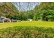 Large green backyard featuring an outdoor kitchen, above ground swimming pool, and storage shed at 105 Kirkland Ct, Archer Lodge, NC 27527