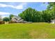Expansive backyard with a pool, outdoor seating, lush greenery, and home's back facade at 105 Kirkland Ct, Archer Lodge, NC 27527
