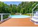 Above-ground swimming pool with surrounding deck and white stairs in a green backyard at 105 Kirkland Ct, Archer Lodge, NC 27527