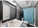 Neutral bathroom featuring a dark framed mirror, blue shower curtain, and updated fixtures at 109 Winding Creek Dr, Youngsville, NC 27596
