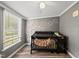 Cozy Bedroom featuring a crib with decorative banner, light fixture, and a beautiful tree wall decal at 109 Winding Creek Dr, Youngsville, NC 27596