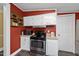 Traditional kitchen featuring red walls, white cabinets, stainless steel oven, and wood shelving at 109 Winding Creek Dr, Youngsville, NC 27596