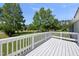 A white wood porch offers a lovely outdoor space with views of the green yard and trees beyond at 109 Winding Creek Dr, Youngsville, NC 27596