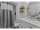 Updated bathroom featuring a round mirror, modern vanity, and tub/shower combo at 11 Stone Village, Durham, NC 27704