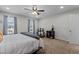 Well-lit bedroom with neutral colors, ceiling fan, and patterned curtains at 11 Stone Village, Durham, NC 27704