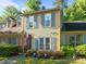 Charming two-story townhome with tan siding, gray shutters, and an American flag at 11 Stone Village, Durham, NC 27704