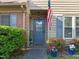 Inviting front entrance with a blue door, flower pots, and lush landscaping at 11 Stone Village, Durham, NC 27704