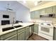 Open kitchen featuring green cabinets, granite counters, and stainless steel appliances at 11 Stone Village, Durham, NC 27704