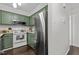 Well-lit kitchen featuring green cabinets, stainless steel appliances, and granite countertops at 11 Stone Village, Durham, NC 27704