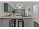 Kitchen bar featuring green cabinets, stainless steel appliances, and granite countertops at 11 Stone Village, Durham, NC 27704