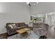 Bright living space with wood floors, a comfortable sofa, and seamless flow to the kitchen at 11 Stone Village, Durham, NC 27704