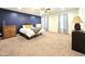 Spacious main bedroom featuring blue accent wall, ceiling fan, and neutral carpet at 11 Stone Village, Durham, NC 27704