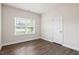 Well-lit bedroom with hardwood floors, a window, and a white door, offering a serene space at 11 Woodwater Cir, Lillington, NC 27546