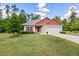 Charming single-story home featuring a well-manicured lawn, red accents, and a two-car garage at 11 Woodwater Cir, Lillington, NC 27546