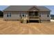 A newly constructed backyard featuring an unfinished lawn and a wooden deck at 112 Royal Ave, Selma, NC 27576
