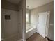 Bathroom features a glass shower, a soaking tub, and a window at 112 Royal Ave, Selma, NC 27576