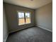 This is a carpeted bedroom with a large window providing lots of light and views into the yard at 112 Royal Ave, Selma, NC 27576