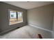 A well-lit bedroom with neutral walls, white trim, a window offering outdoor views, and unfinished flooring at 112 Royal Ave, Selma, NC 27576