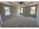 Large bedroom with a tray ceiling, carpeted flooring, and natural light; a serene retreat for relaxation and rest at 112 Royal Ave, Selma, NC 27576