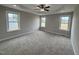 Spacious main bedroom featuring a tray ceiling with ceiling fan and neutral carpet at 112 Royal Ave, Selma, NC 27576