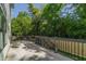 Open back deck area with gray metal railings, stairs down to backyard, and surrounded by mature trees at 1124 Upchurch St, Raleigh, NC 27610