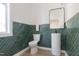 Bathroom with stylish, emerald tile, pedestal sink, and toilet at 1124 Upchurch St, Raleigh, NC 27610