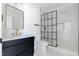Modern bathroom featuring a black vanity, white countertop, grid style glass shower surround, and a black framed mirror at 1124 Upchurch St, Raleigh, NC 27610