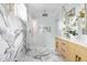 An elegant bathroom with marble floors and walls, gold hardware, and a glass walk-in shower at 1124 Upchurch St, Raleigh, NC 27610