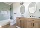 Bathroom showcasing double sinks with modern fixtures, light blue tile, and bathtub with shower at 1124 Upchurch St, Raleigh, NC 27610