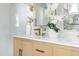 A close up of a sink with marble backsplash, white flowers, and gold hardware at 1124 Upchurch St, Raleigh, NC 27610