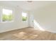 Bright bedroom featuring wood-look floors, white walls, and two windows offering natural light at 1124 Upchurch St, Raleigh, NC 27610