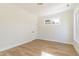 Bright bedroom featuring wood-look floors, white walls, white trim, and one window offering natural light at 1124 Upchurch St, Raleigh, NC 27610