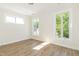 Light filled bedroom with views from three windows, light-colored walls, and wood-look flooring at 1124 Upchurch St, Raleigh, NC 27610